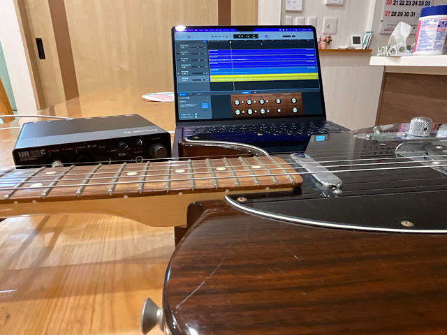 テーブルにPCとオーディオインタフェースとギター